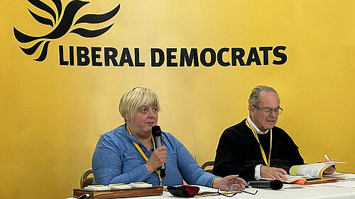 People in front of a Lib Dem conference sign