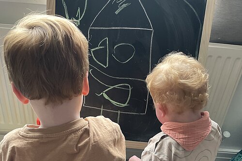 Kids drawing on chalkboard